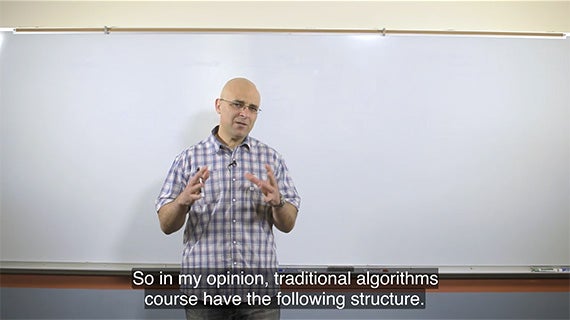 A man wearing glasses stands confidently in front of a whiteboard, ready to present his ideas.